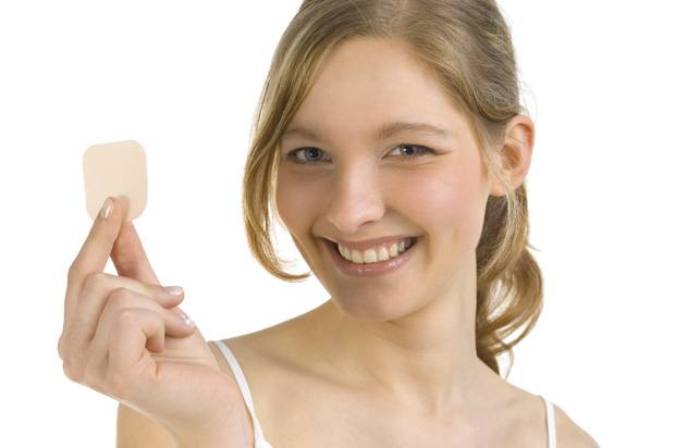 Yound woman holding a contraceptive patch