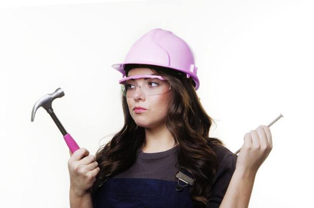 Girl with a pink hard hat and hammer