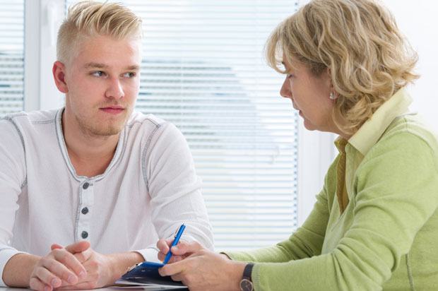 Young man sat talking to therapist or doctor