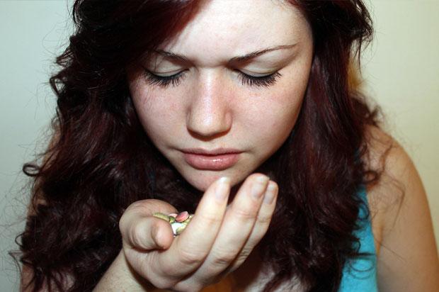 Girl holding pills in her hand