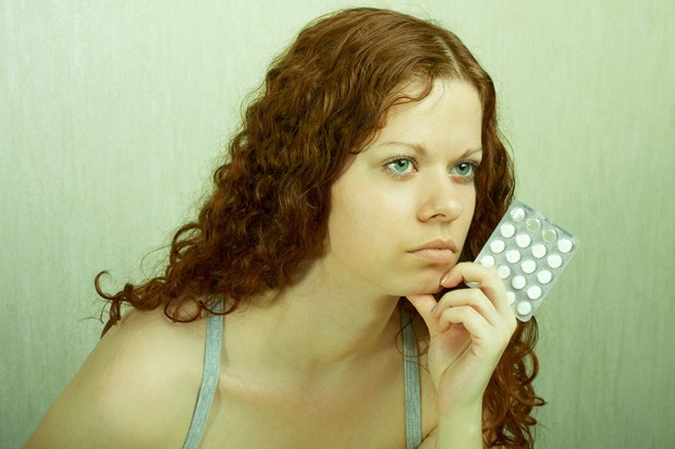 Girl looking sad with pills