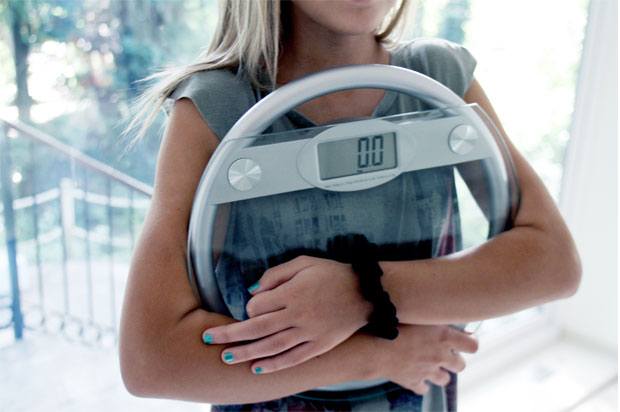 Girl holding electronic weighing scales