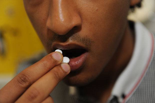 Close-up of boy taking pills