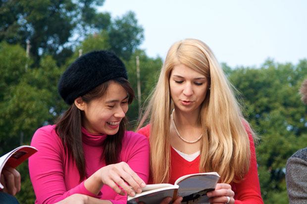 two female students looking at a book