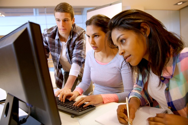 three students looking at a computer