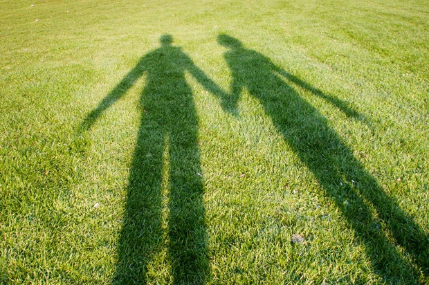 Shadow of two people holding hands.