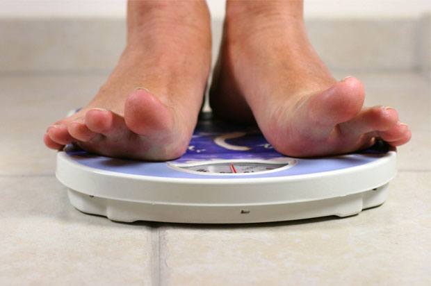 Feet of someone standing on blue weighing scales