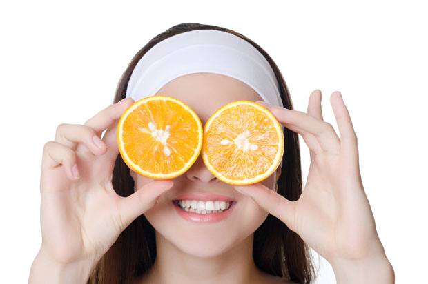 Girl with fruit held over her eyes