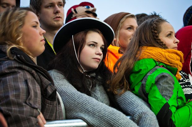 Girl wearing hat looking sad in festival crowd