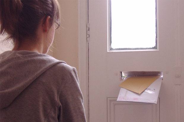 girl watching post come through letter box