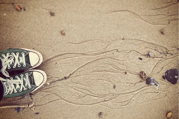 Someone's converse on a sandy beach