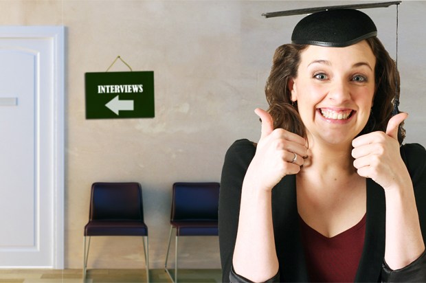Girl outside of interview office wearing a mortarboard