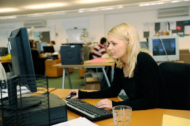 Girl sat in office at a computer