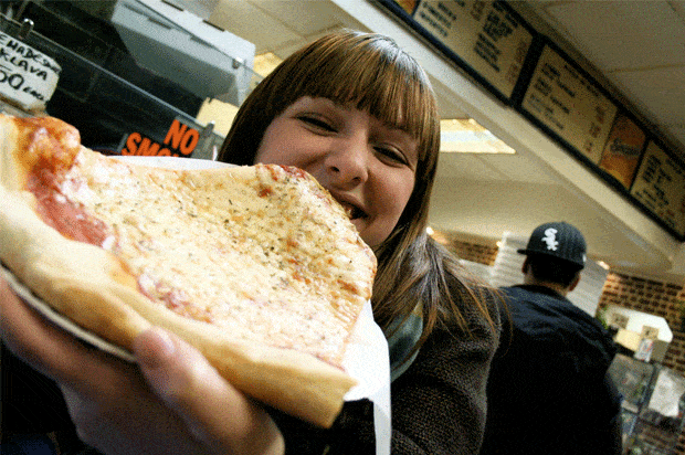girl eating big slice of pizza