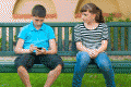 young girl and boy sit on a bench