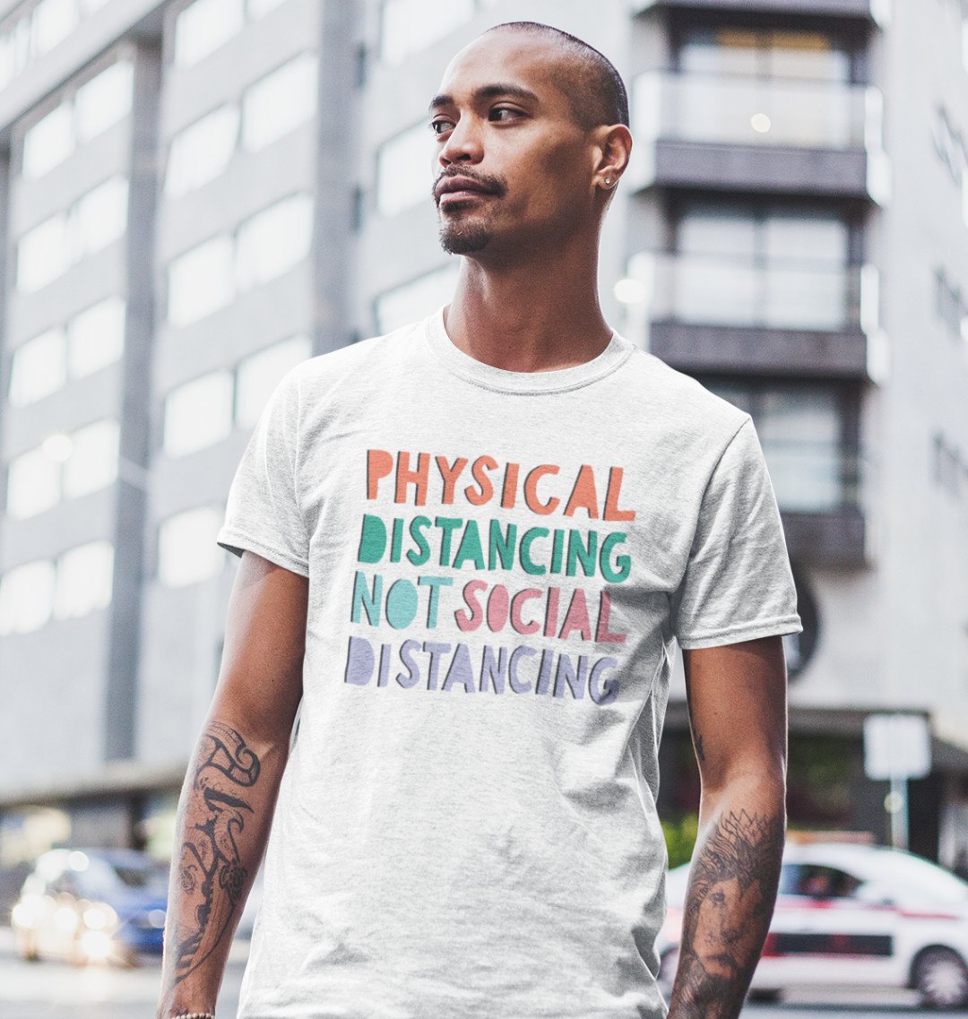 A young man wears a Mix t shirt that reads: "Physical distancing not social distancing"